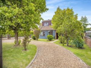 a home with a gravel driveway and trees at Casa Mia in Terrington Saint John