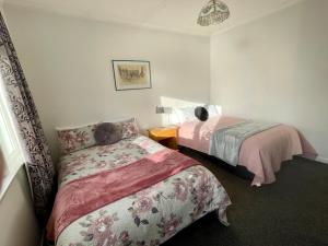 sypialnia z 2 łóżkami i szafką nocną w obiekcie Bungalow on Centre w mieście Invercargill