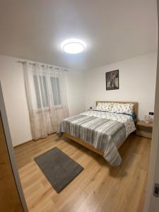 sypialnia z łóżkiem i drewnianą podłogą w obiekcie Roberto w Fažanie