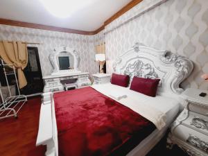 a bedroom with a large white bed with red pillows at Private Hall Room Bed Room and Washroom Room In Shared Apartment Flat 302-1 in Abu Dhabi