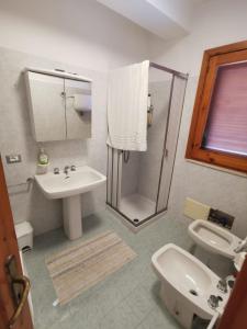 ein Bad mit einer Dusche, einem Waschbecken und einem WC in der Unterkunft BALCONE DI MARE in Otranto