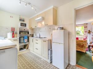 uma cozinha com armários brancos e um frigorífico branco em Bryanstown Annexe em Woodbridge