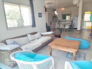 a living room with a couch and a table at הממלכה הקסומה של מאיה ושלושת הפיות in Gonen