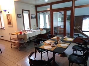 Hotel Bel Sit في ماديسيمو: غرفة طعام مع طاولة وكراسي ومطبخ