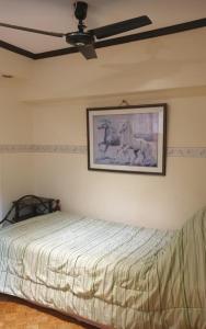 a bedroom with a bed and a painting on the wall at Greenhills Garden Square 2BR & 2 Toilets in Manila