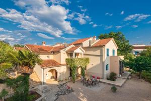 una vista exterior de una casa con patio en APARTMAN IVONA NA 1. KATU, en Malinska