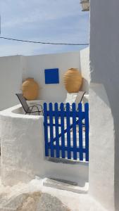 zwei blaue Stühle und ein Zaun in einem Gebäude in der Unterkunft StathisApart1 in Amorgós
