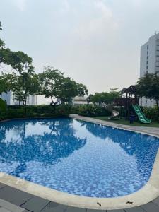 ein blauer Pool mit Rutsche und Spielplatz in der Unterkunft Air Residences 1-Bedroom condo in Makati in Manila