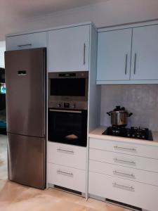 a kitchen with white cabinets and a stainless steel refrigerator at AVRA-3 Luxury Apartment in Potamós