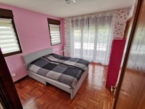 um quarto com uma cama e uma parede rosa em VILLA TOMILLARES em Los Tomillares