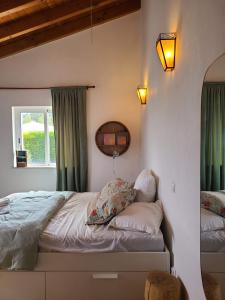 a bedroom with a bed with green curtains at Casa Ensolarada B&B and Pottery in Aljezur