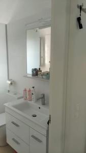 bagno bianco con lavandino e specchio di AVRA-3 Luxury Apartment a Potamós