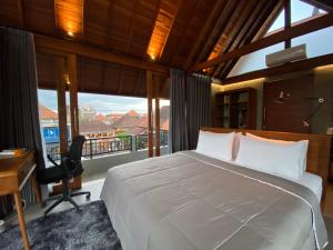 a bedroom with a bed and a desk and a window at Dewa Hostel in Ubud