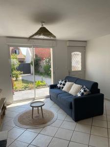 a living room with a blue couch and a table at La Blériotine in Sangatte