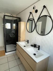 a bathroom with a sink and a shower and a mirror at La Blériotine in Sangatte +22 photos