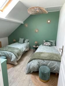 2 Betten in einem Schlafzimmer mit blauen Wänden in der Unterkunft La Blériotine in Sangatte