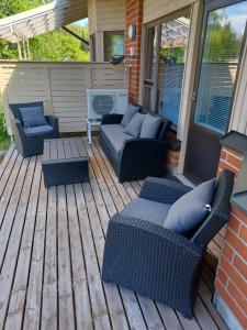 a patio with couches and a table on a deck at Peltorinne 14 in Savonlinna