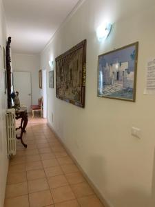 un pasillo con pinturas en la pared y una mesa en Dimora Di Mare Gallipoli, en Gallipoli
