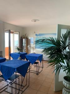 a group of blue tables and chairs with blue umbrellas at Dimora Di Mare Gallipoli in Gallipoli