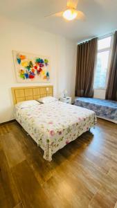 1 dormitorio con 1 cama con colcha de flores en Apartamento Xavier da Silveira 40, en Río de Janeiro