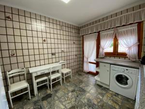 lavadero con mesa, sillas y lavadora en Casa Juani en Ateca