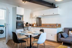 eine Küche und ein Esszimmer mit einem Tisch und Stühlen in der Unterkunft Joli T2 - Hennebont centre in Hennebont