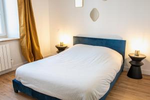 ein Schlafzimmer mit einem großen Bett mit zwei Nachttischen in der Unterkunft Joli T2 - Hennebont centre in Hennebont