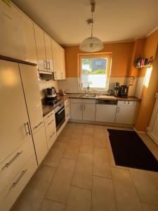 a kitchen with white cabinets and a tile floor at Sunnyside Hasloh 