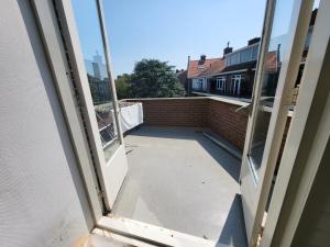 een open raam met uitzicht op een balkon bij Beautiful spacious appartment at top location The Hague in Den Haag