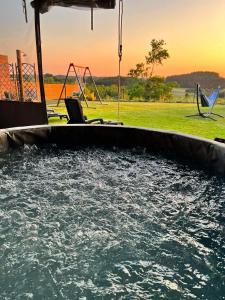 una piscina de agua con una mesa y un columpio en Apartament Nadziei, en Chmielno