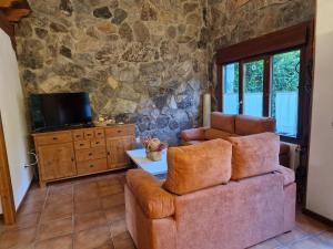 a living room with a couch and a tv at El Descanso de Sanabria in Trefacio