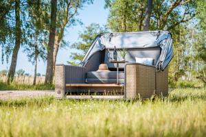 an old van with a canopy sitting in the grass at Marina Martinshafen - Beach life in Sassnitz