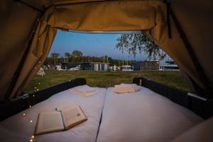 - un lit dans une tente avec un livre dans l'établissement Marina Martinshafen - Beach life, à Sassnitz