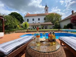 een tafel met wijnflessen en glazen naast een zwembad bij Vácon Vár-lak Vendégház / Bird Nest Vác in Vác