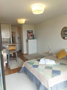 ein kleines Schlafzimmer mit einem Bett und einer Küche in der Unterkunft Studio ultra cosy et chic avec vue sur l'océan 3* in Seignosse