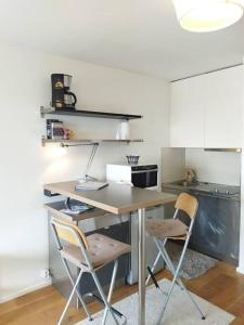 eine Küche mit einem Schreibtisch und 2 Stühlen in der Unterkunft Studio ultra cosy et chic avec vue sur l'océan 3* in Seignosse