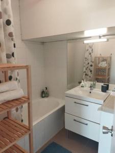 een badkamer met een wastafel, een bad en een wastafel bij Studio ultra cosy et chic avec vue sur l'océan 3* in Seignosse