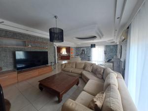 a living room with a couch and a flat screen tv at Welcome Home in Rhodes Town