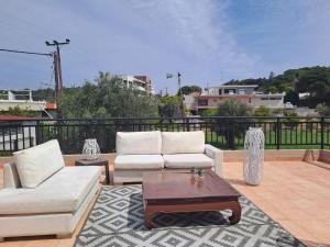 a patio with two white couches and a coffee table at Welcome Home in Rhodes Town