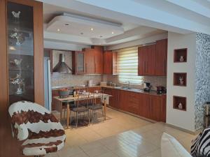 a kitchen with wooden cabinets and a table and chairs at Welcome Home in Rhodes Town