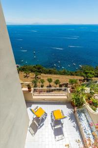 balcone con tavoli, sedie e vista sull'oceano di La Terrazza Amalfi ad Amalfi