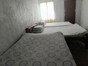 2 camas individuais num pequeno quarto com uma janela. em Magic's Place Beach Resort em Moalboal