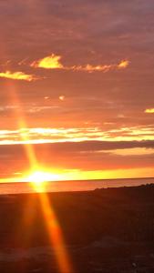 un tramonto sull'oceano con il sole nel cielo di Belstane House a Cellardyke