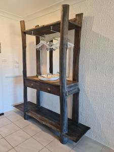 ein Holzregal mit einem Spiegel an der Wand in der Unterkunft Vacy Hunter Valley Lodge in Vacy