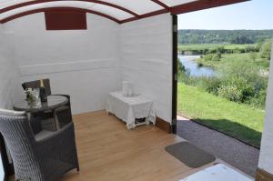 a patio with a table and a view of a river at Locksters lodges in Hereford