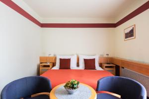 Pokój z łóżkiem z niebieskimi krzesłami i stołem w obiekcie Jan Maria Hotel & Restaurant w Ostravie