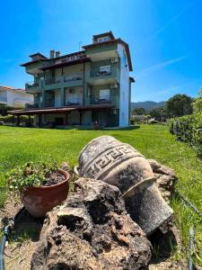 a building with a rock and a plant in front of it at Alexandros Hotel Apartments in Vourvourou