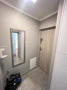 a bathroom with a mirror and a vacuum at Apartament Portowa in Kołobrzeg