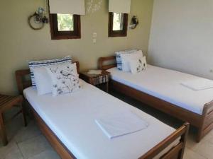 two beds in a room with white sheets at Avra Ηouse in Kriopigi