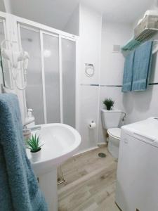 a white bathroom with a sink and a toilet at Estudio Copenhague in Torremolinos